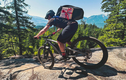mountain biker riding with sack of holiday gifts