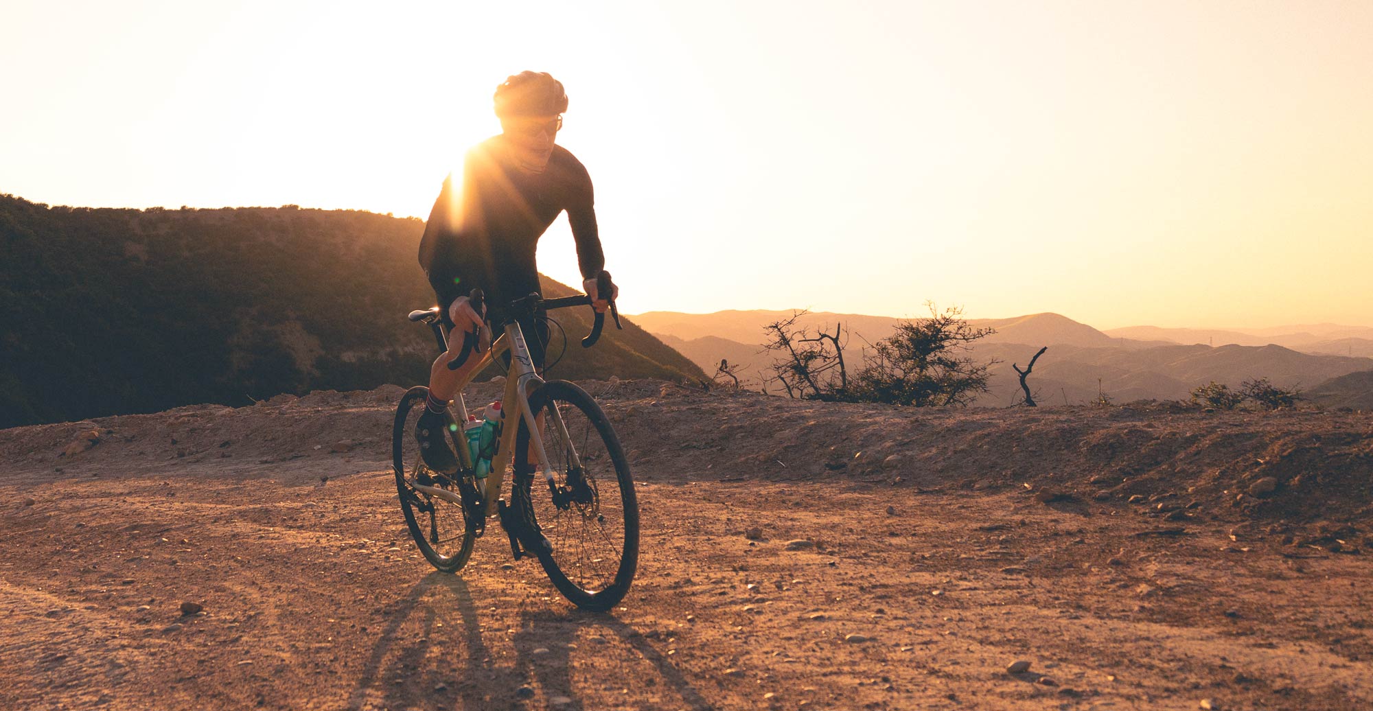 cyclist riding gravel bike as the sun sets in Socal
