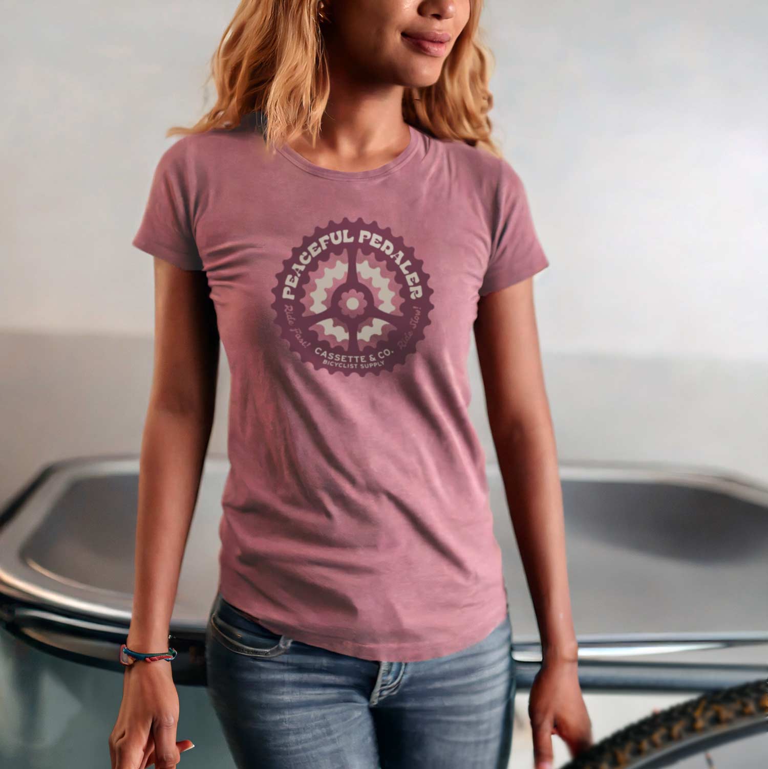 woman wearing faded pink Peaceful Pedaler tee with 2 color print