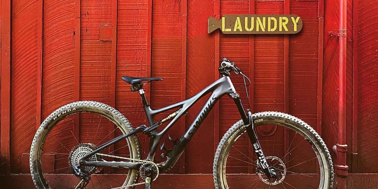 mountain bike leaning on a red wall with laundry sign