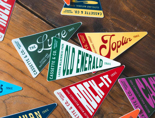 Group of trail pennant stickers on wood tabletop